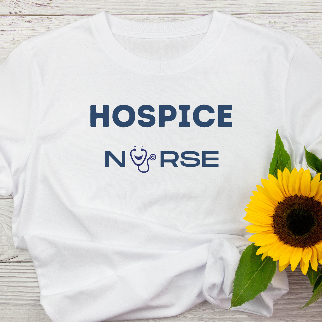 White styled t-shirt that says Hospice Nurse. There is a stethoscope logo in place of the U in nurse. There is also a sunflower on top of the shirt